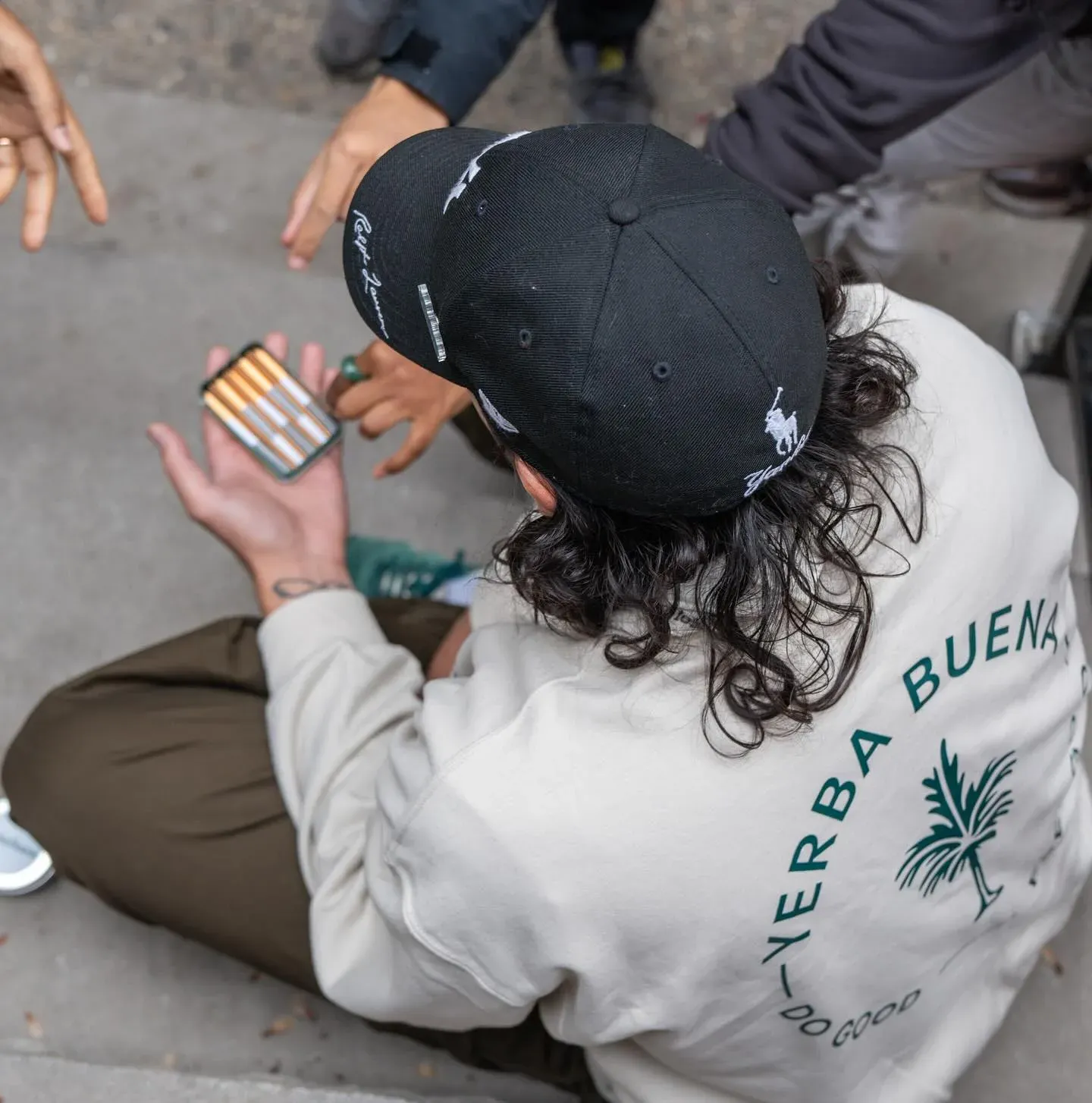 A Yerba Buena team member holding a product package while surrounded by friends.